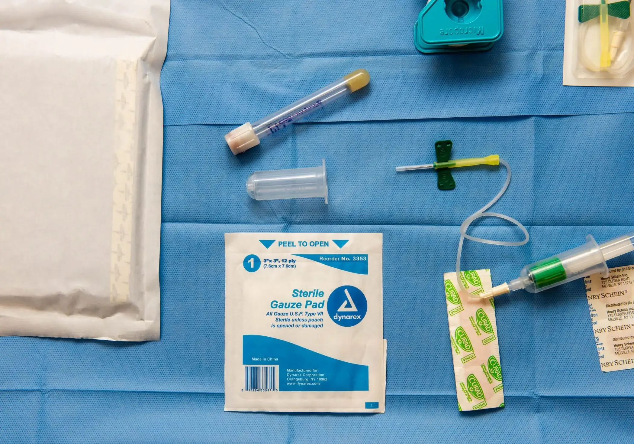 Medical supplies on a blue sterile cloth.
